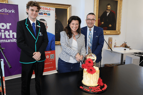 MC for the Launch of the Arts on the Plains Festival, Isaac Thompson and Tony Piccolo MP look on while the State Minister for the Arts, the Hon Andrea Micaels cuts the cake to officially launch the festival.