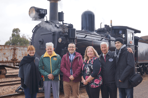 The late George Rau (second from left) at Quorn on 2 June 2019 at the return of the Yx141 locomotive engine. With Mr Rau are (from left) Gawler Mayor Karen Redman, Tony Piccolo MP, Cr Helen Hennessy, Chris McDonald from the Pichi Richi Preservation Society, and Stefan Piccolo. The Yx141 was built at the James Martin Foundry in Gawler in 1892. It was rebuilt in 1923, when it became the Yx141. It spent its later years at the South Australian Railways Port Lincoln Division and retired in 1963. It was then displayed in a playground in Port Lincoln until 1983 when it was acquired by the Pichi Richi Preservation Society and repaired by volunteers. It was relaunched on 2nd June 2019. George Rau was in his element at the re-launch.