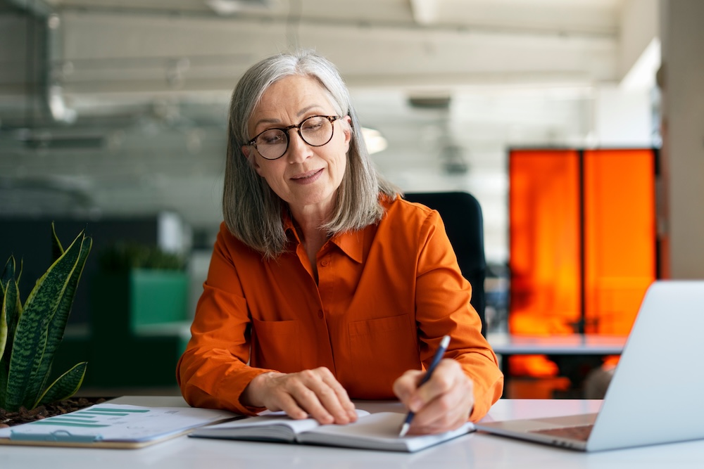 business woman working at her desk writing