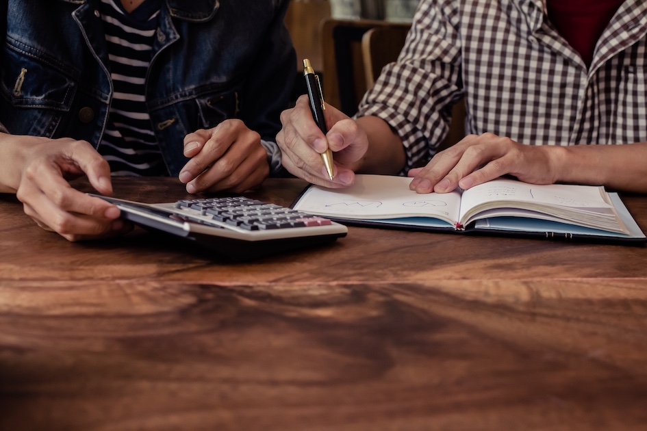two people managing finances at a table no faces