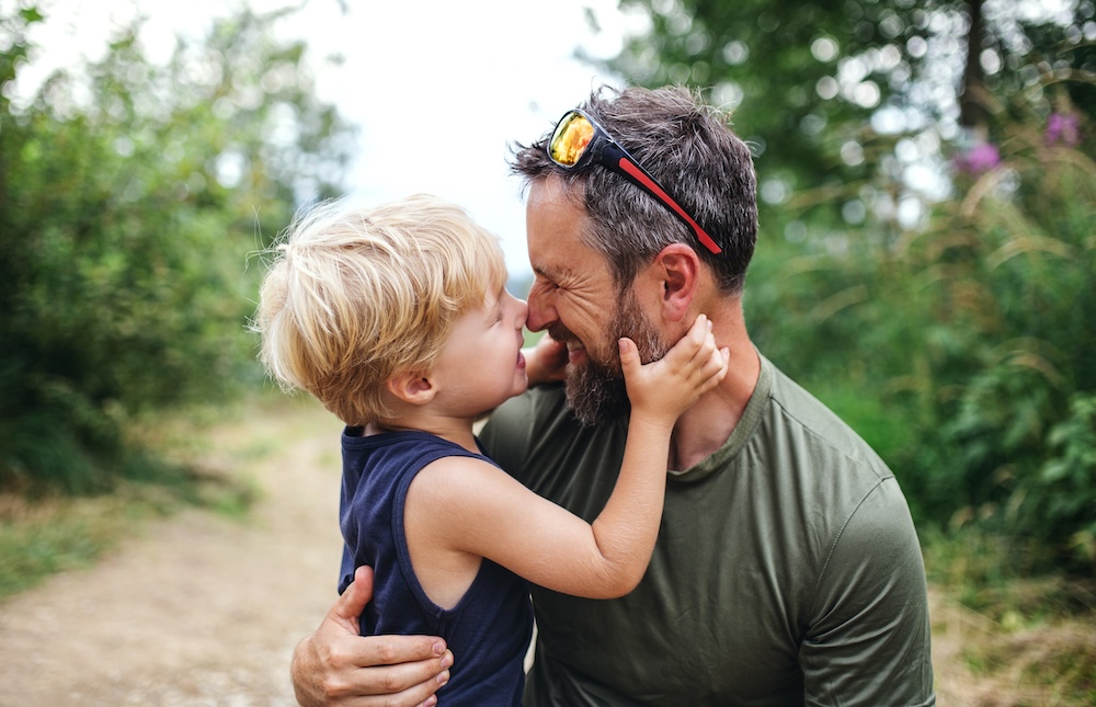 father kid outdoors happy embrace