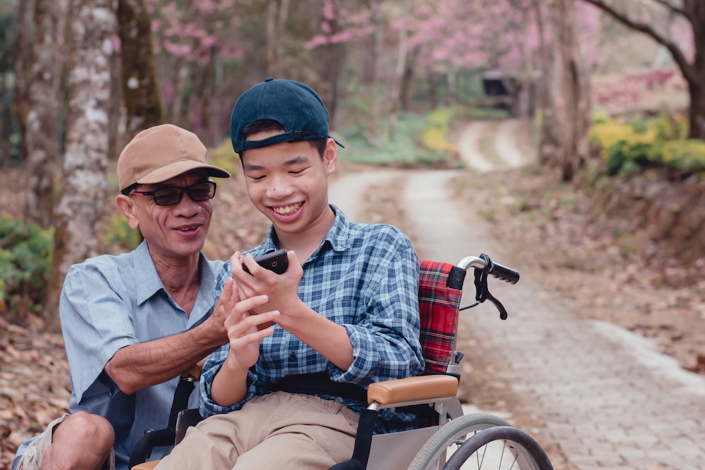 father and son smiling looking at phone