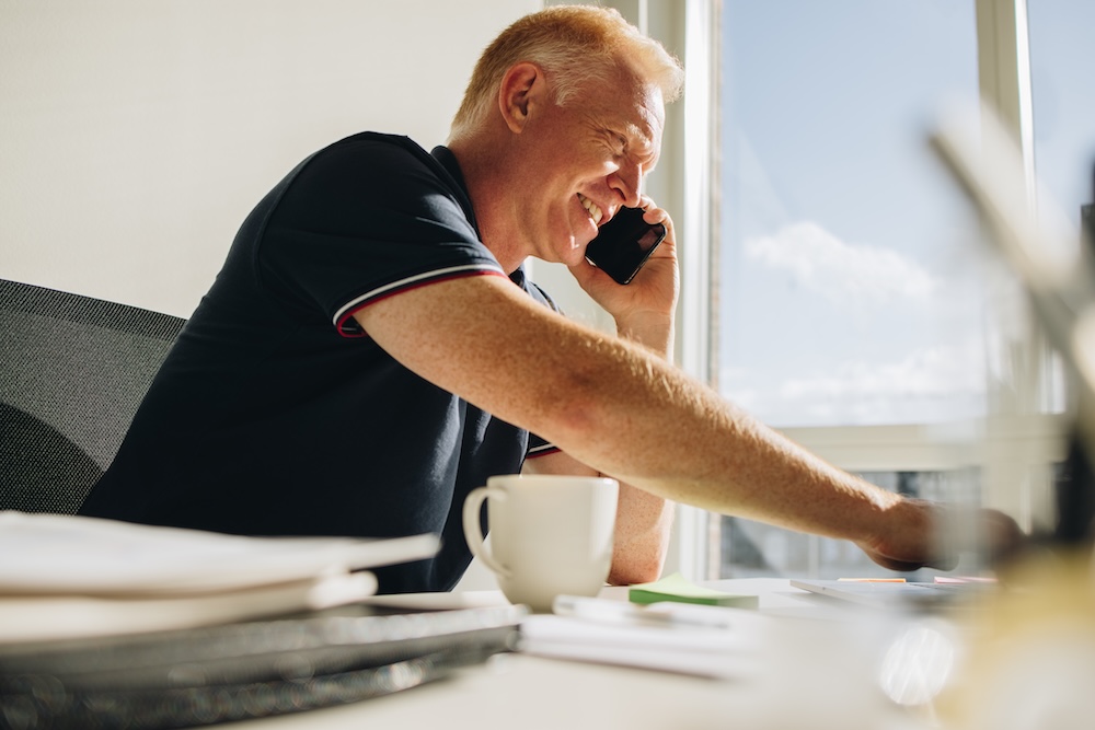 man at desk talking on phone