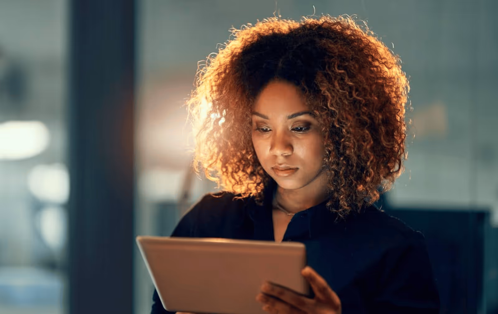 Businesswoman preparing for a fashion trade show using a tablet, symbolizing tech-enabled planning and virtual showroom strategy.