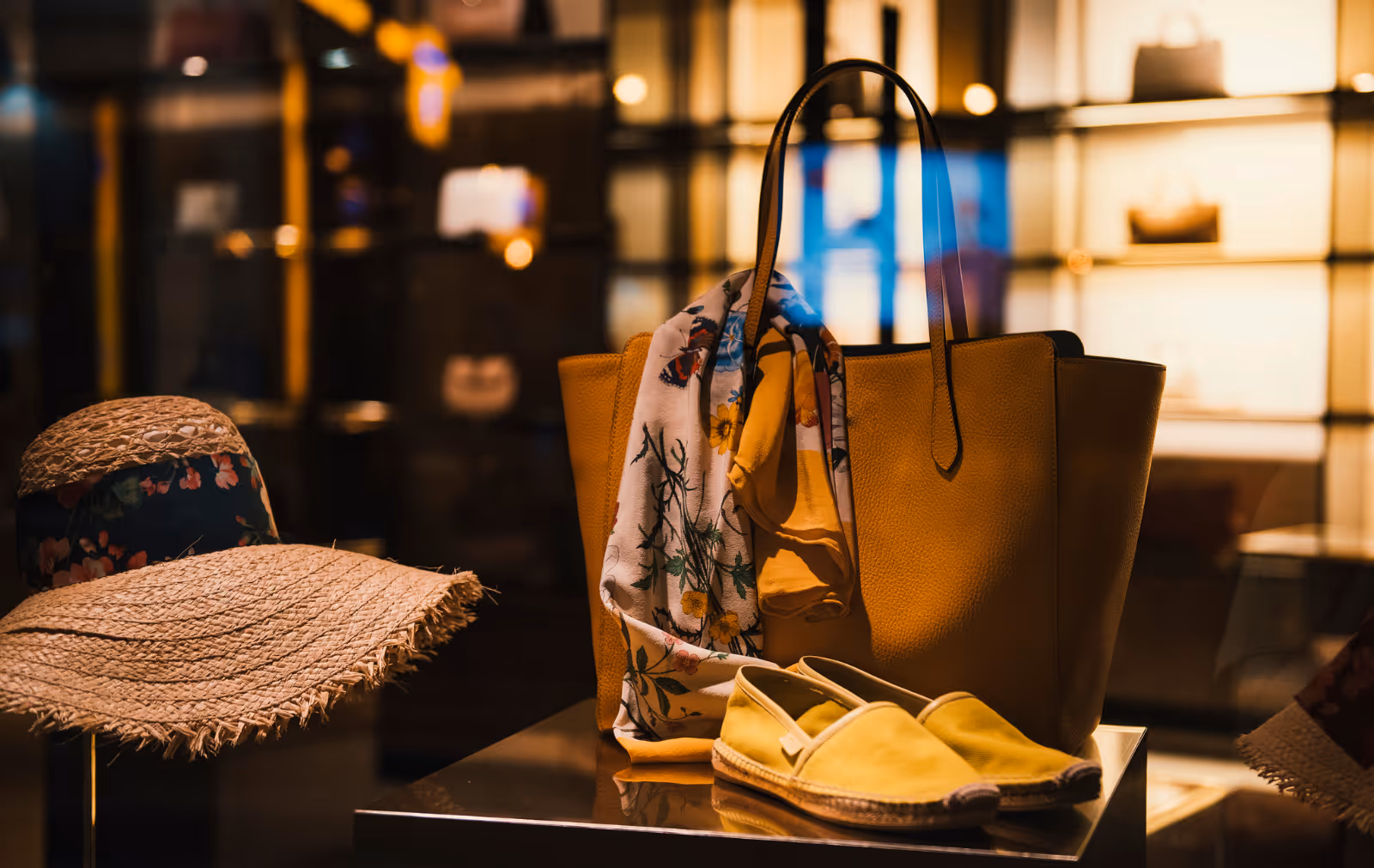 Yellow espadrilles , a summer hat and handbag positioned on a table in a fashion boutique