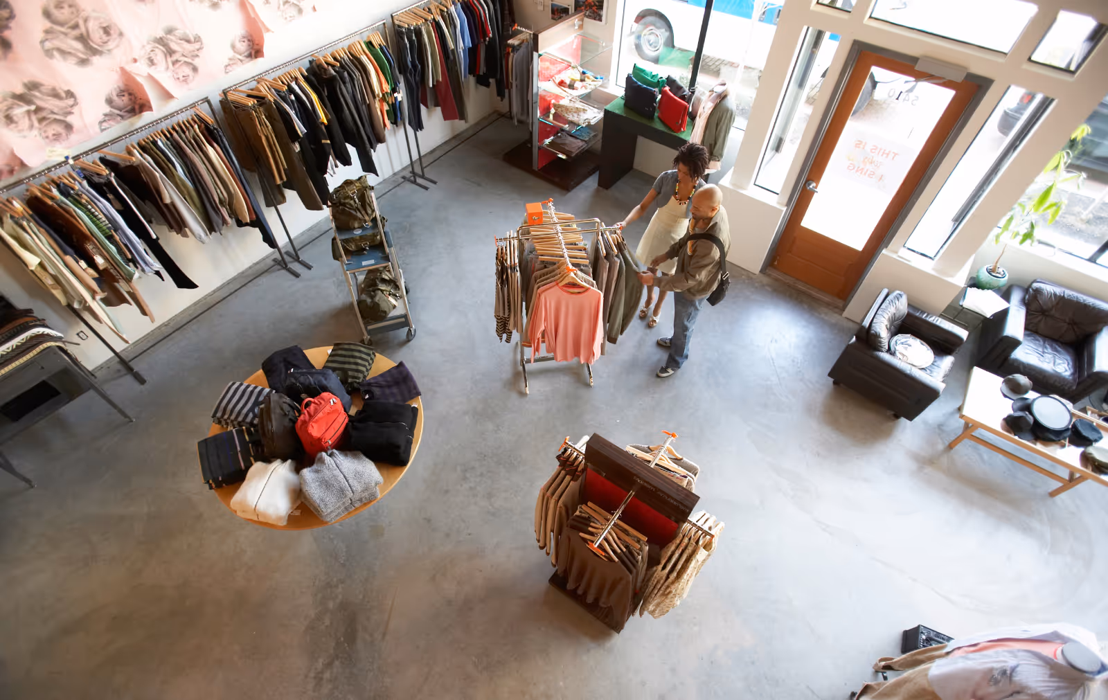 Overhead shot of inside an independent retailer, with clothes stocked on tables and rails