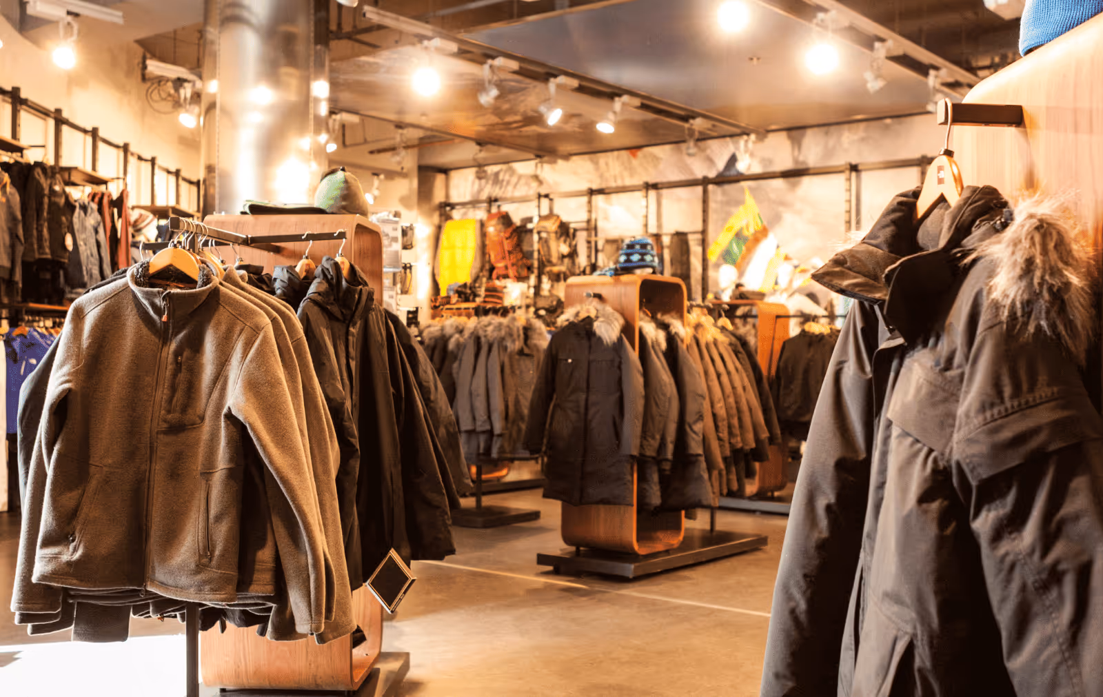 Retail store showcasing winter wholesale apparel and outerwear jackets on display racks, highlighting retail merchandising and fashion wholesale inventory setup.