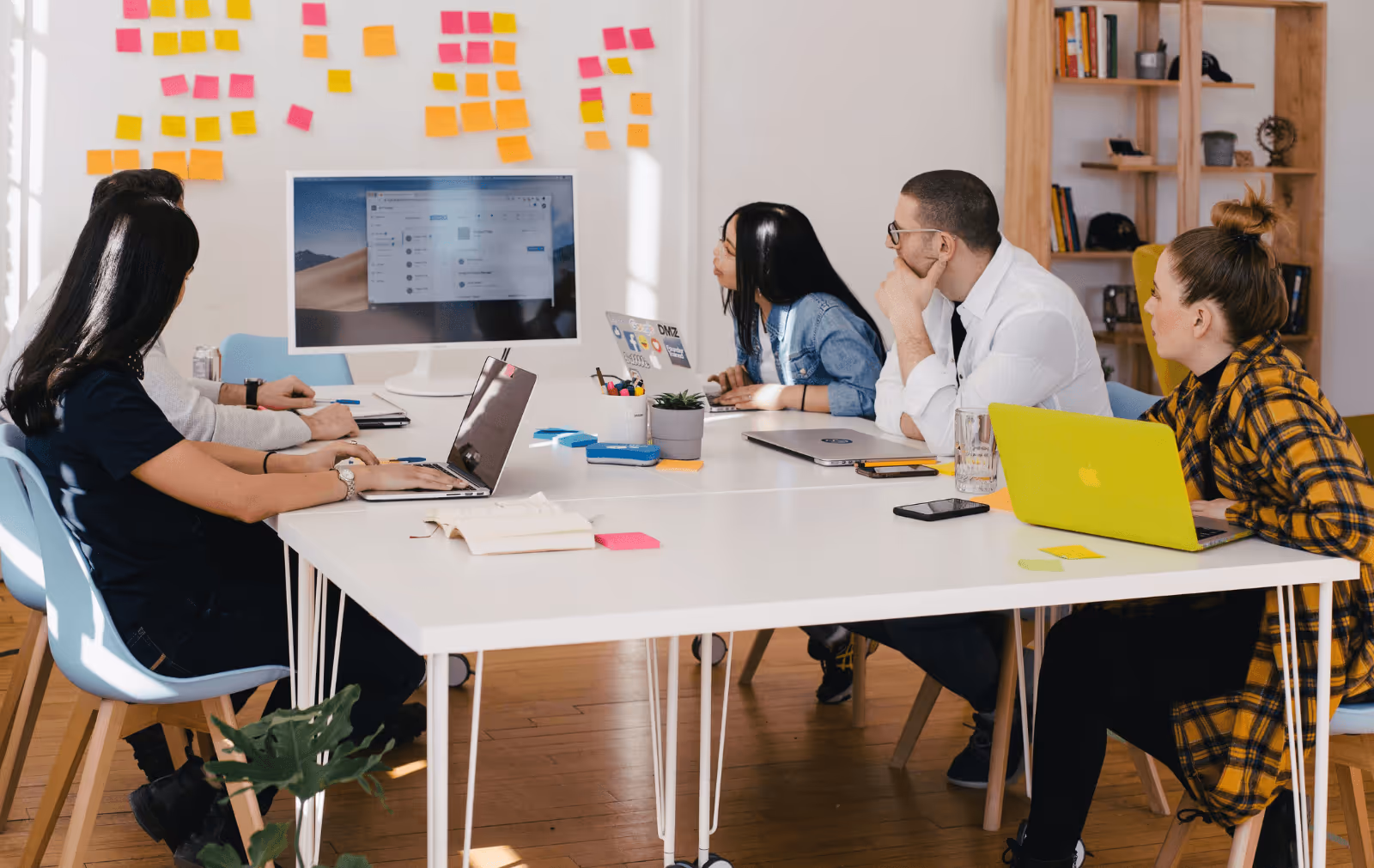 Team collaborating in a modern workspace while evaluating digital tools on screen representing the decision-making process for choosing the right B2B wholesale marketplace platform.