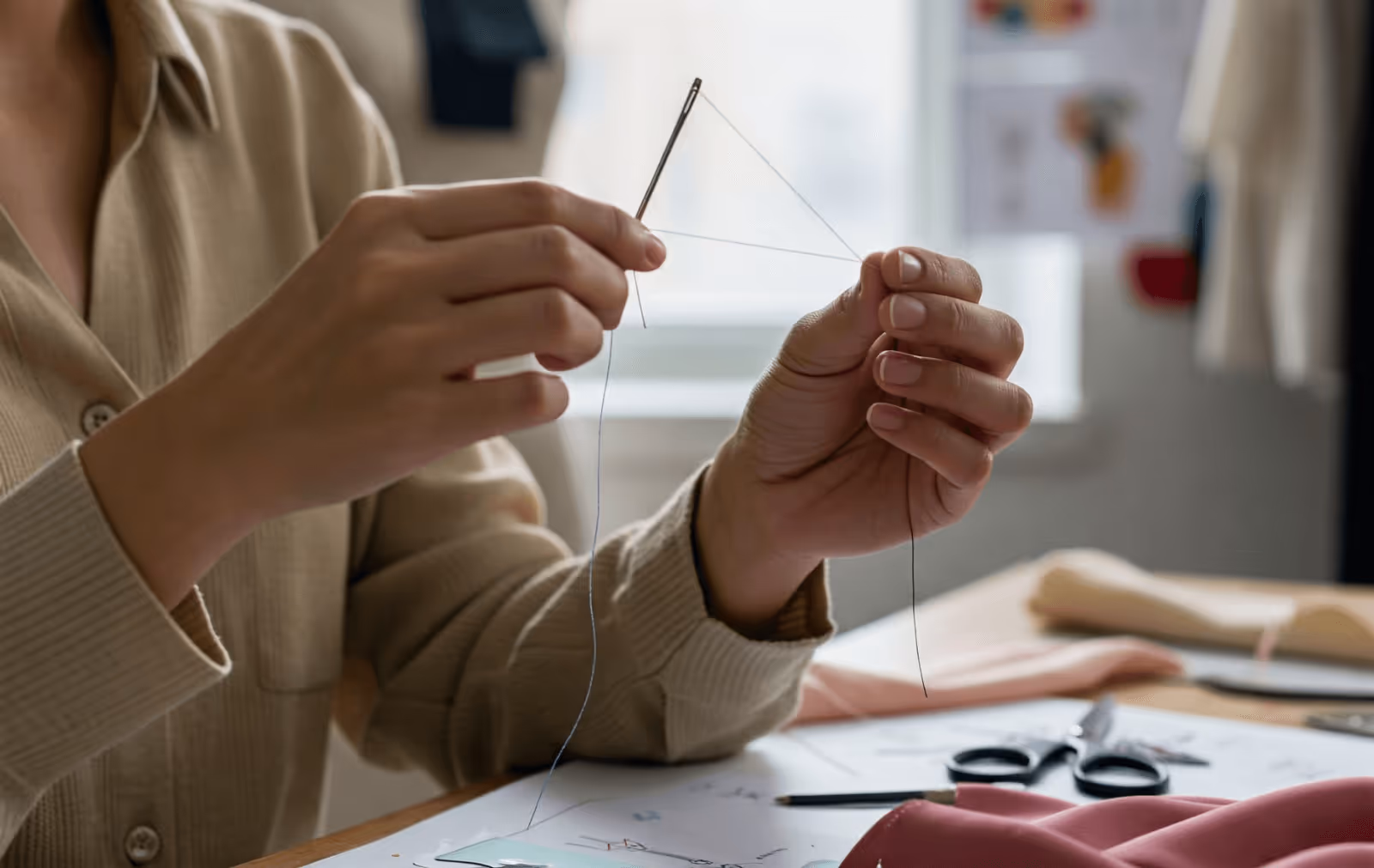 Fashion Designer Threading a Sustainable Yarn Through Needle