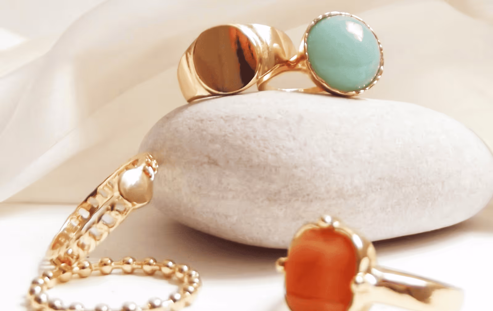 Gold rings with coloured stones under studio lighting