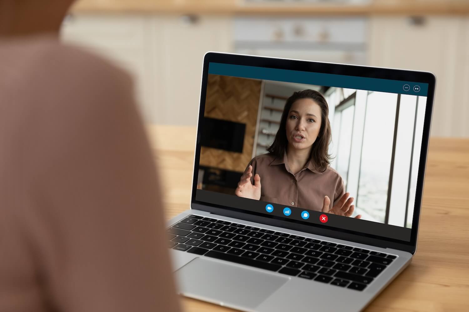 Weibliche Fachkraft, die an einer Videokonferenz zum Coaching von Führungskräften teilnimmt und über eine Laptop-Webcam mit ihrem Coach spricht.