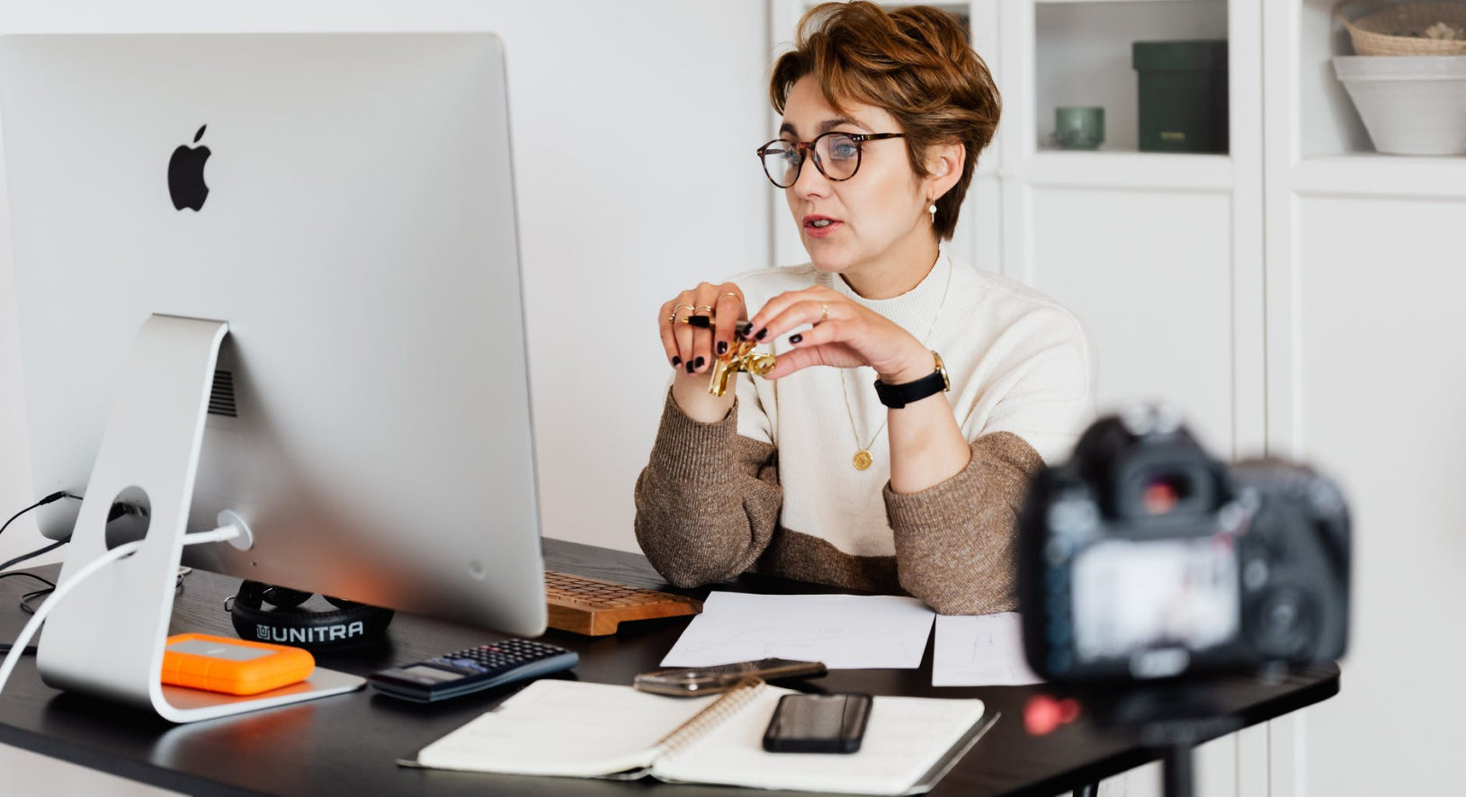 Eine Frau sitzt an ihrem Schreibtisch vor einem Computer und nimmt aktiv an einer digitalen Coaching-Sitzung während einer Online-Sitzung teil.