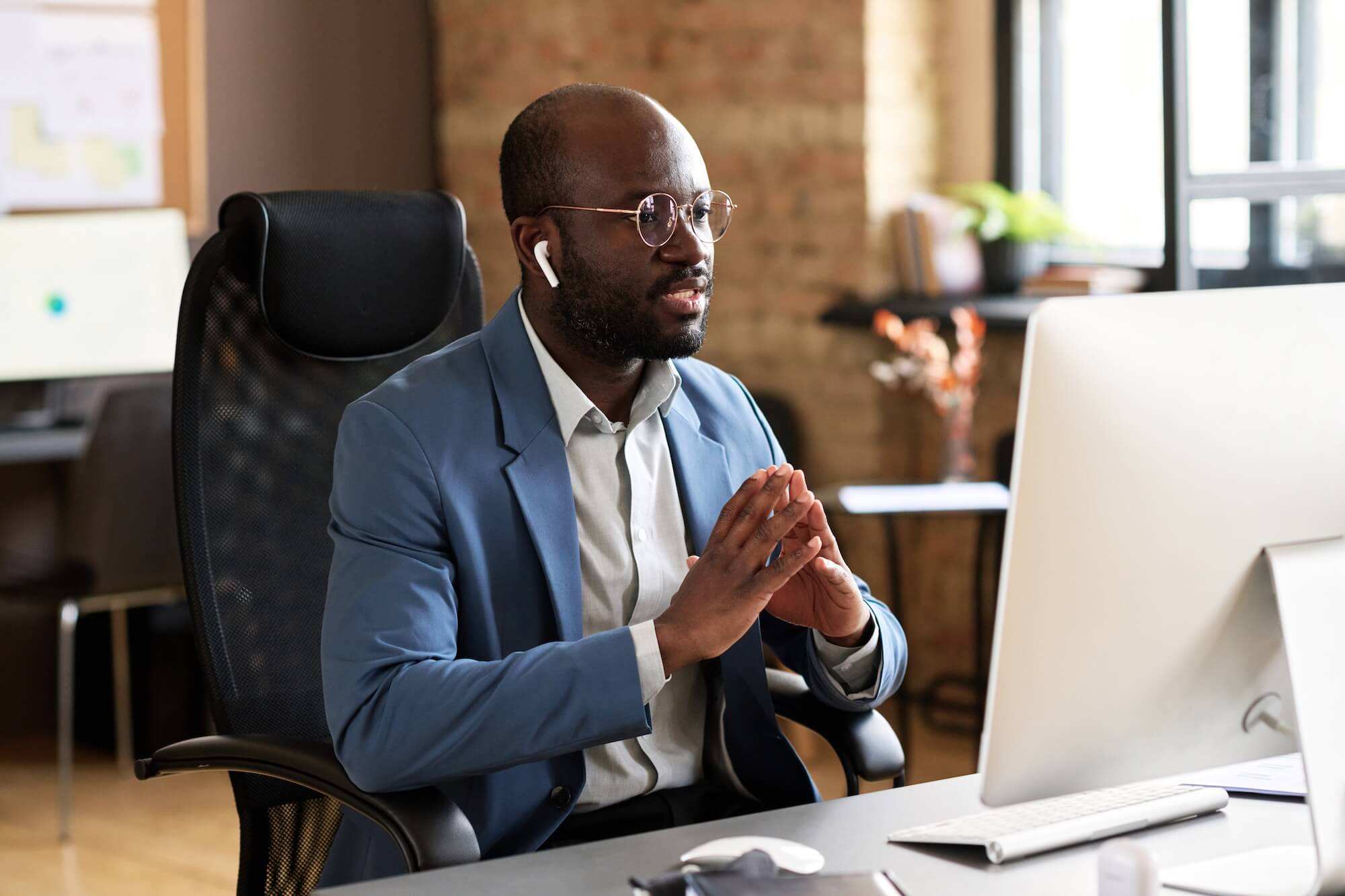 Conducting personalized coaching online: Man conducting a video call on his computer.