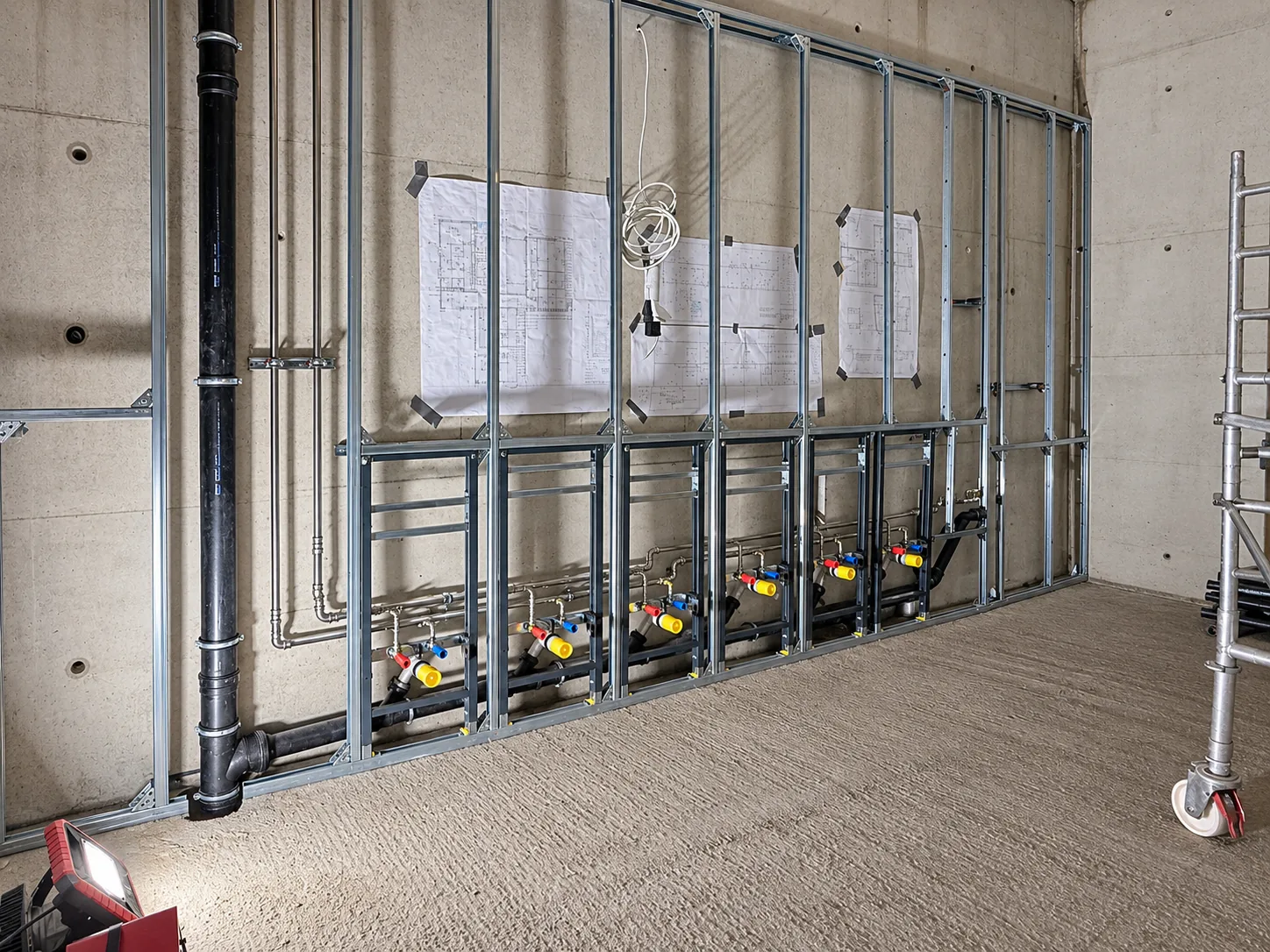 Ständerwerk mit Vorwandinstallation und Ausführungsplänen an der Wand