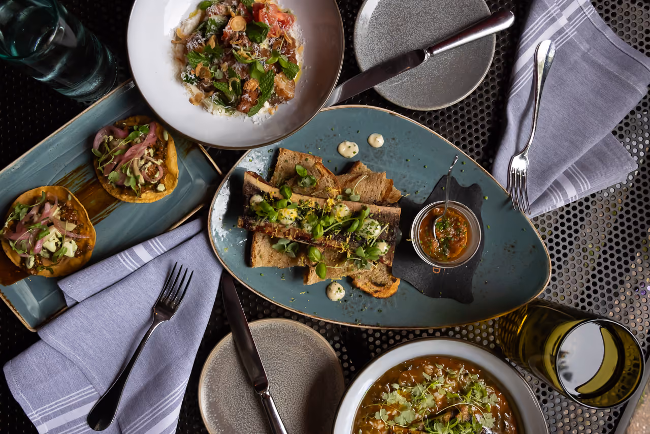 Delicious gourmet dish with flatbread, garnished with herbs and spices, served on a textured table.