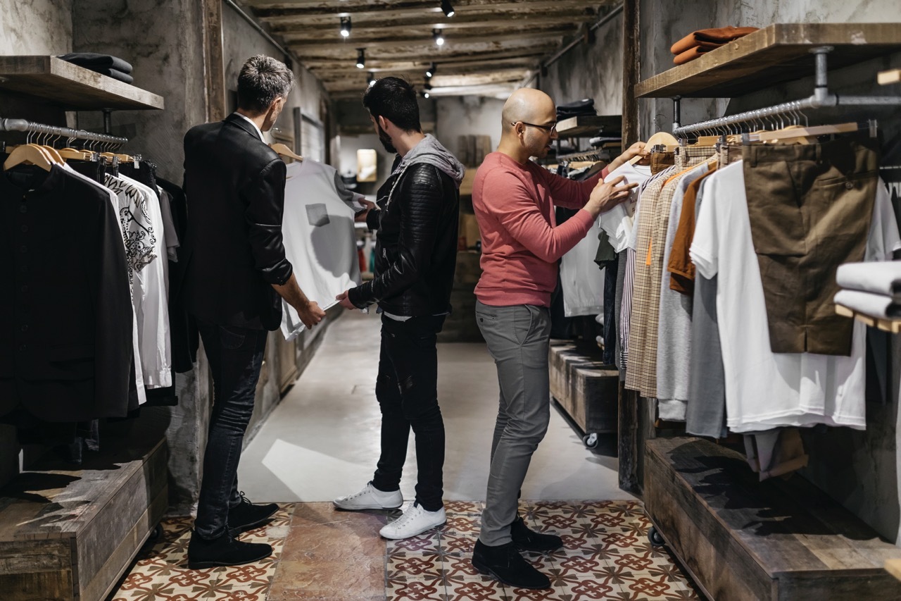 Men inside a men's wear store looking at apparel to show interest in that store.