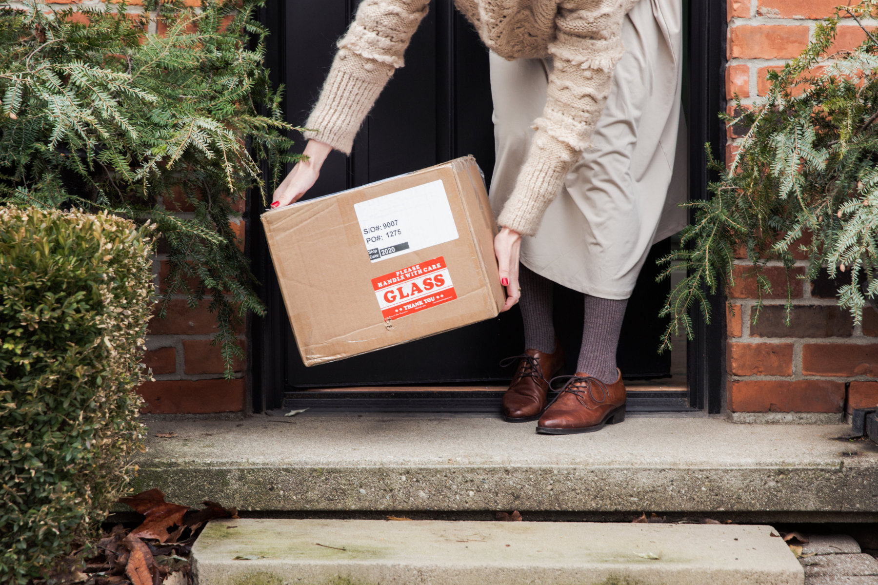 Woman receiving delivered package at doorstep
