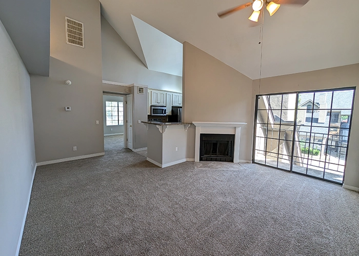 living room with new carpet, tall ceilings, a fireplace and large patio door.