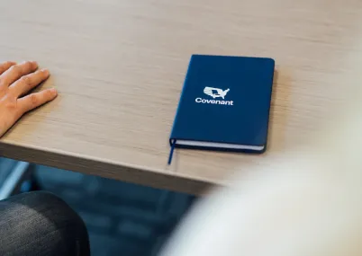 covenant branded notebook on desk