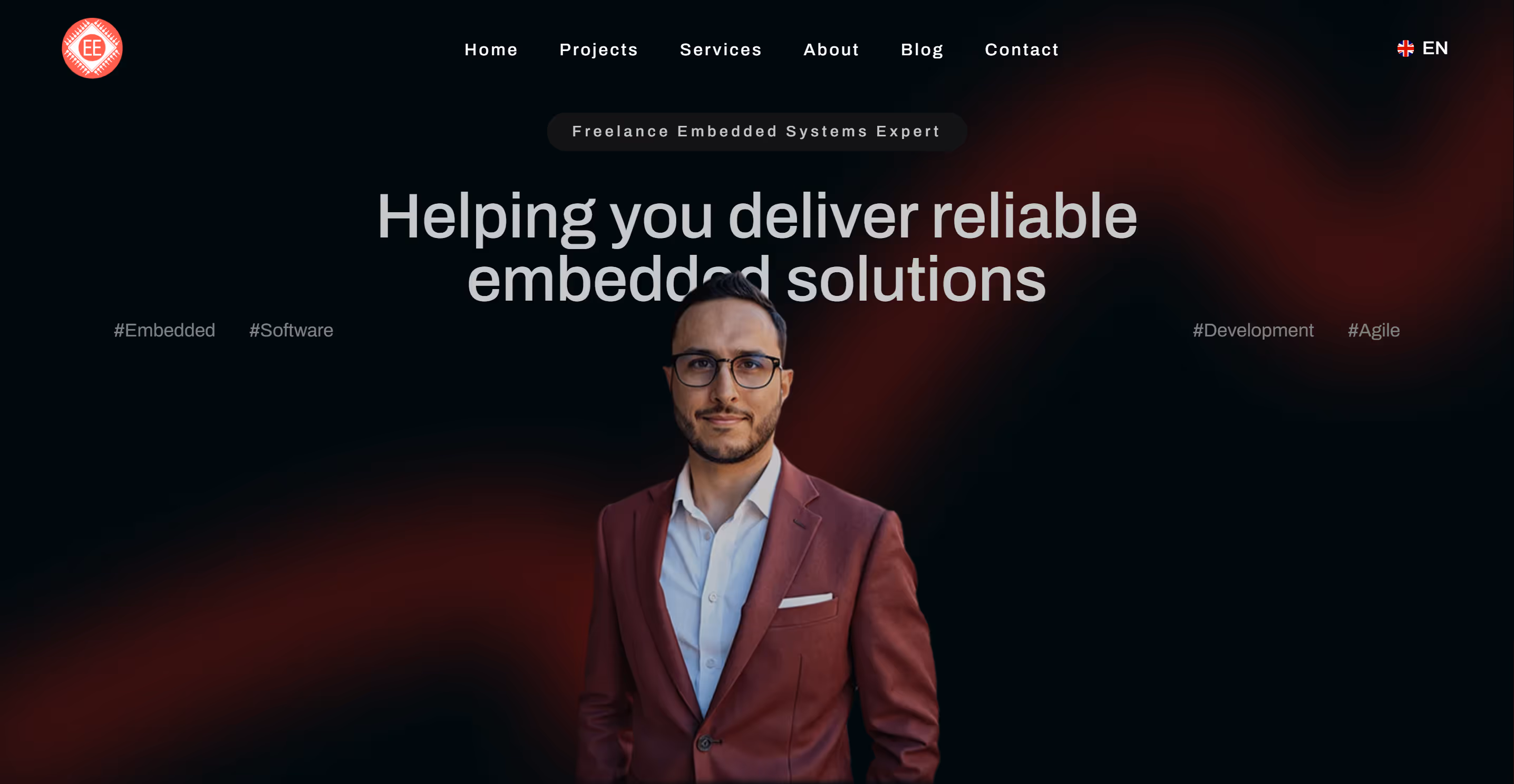 Portrait de Claudio Carbone, consultant freelance en systèmes embarqués, avec slogan “Helping you deliver reliable embedded solutions” sur fond sombre.