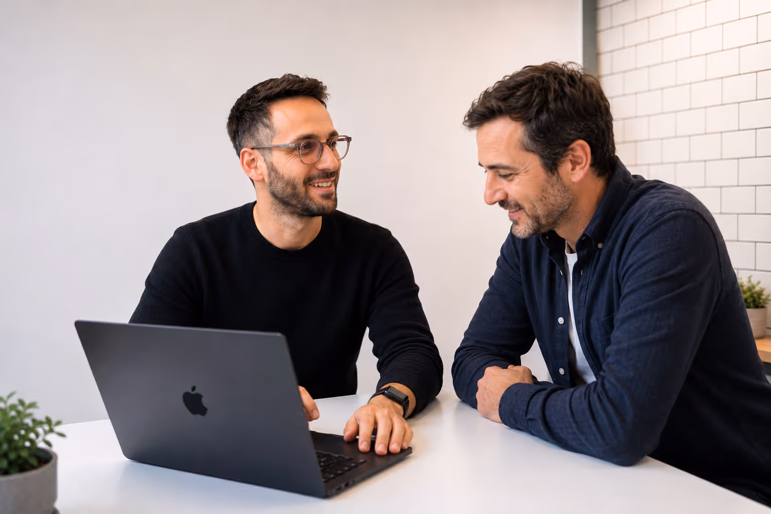 Stefano Fresch, designer UX/UI freelance, en réunion avec un client devant un MacBook