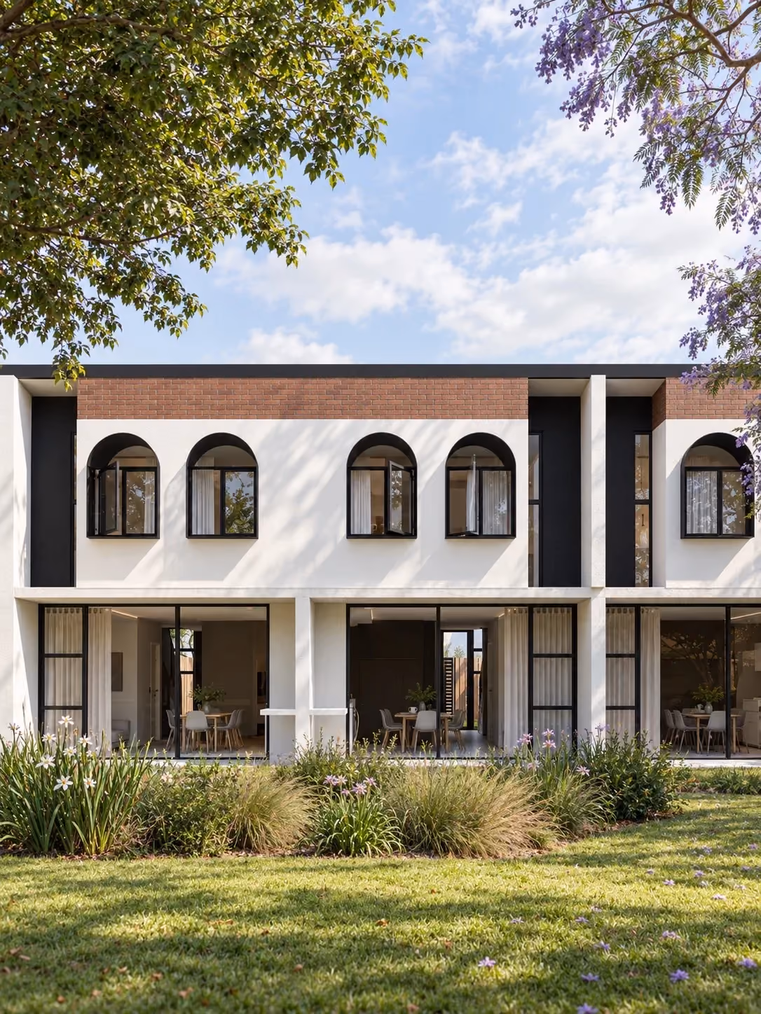Ground floor of the apartments, with arched windows above and gardens in front