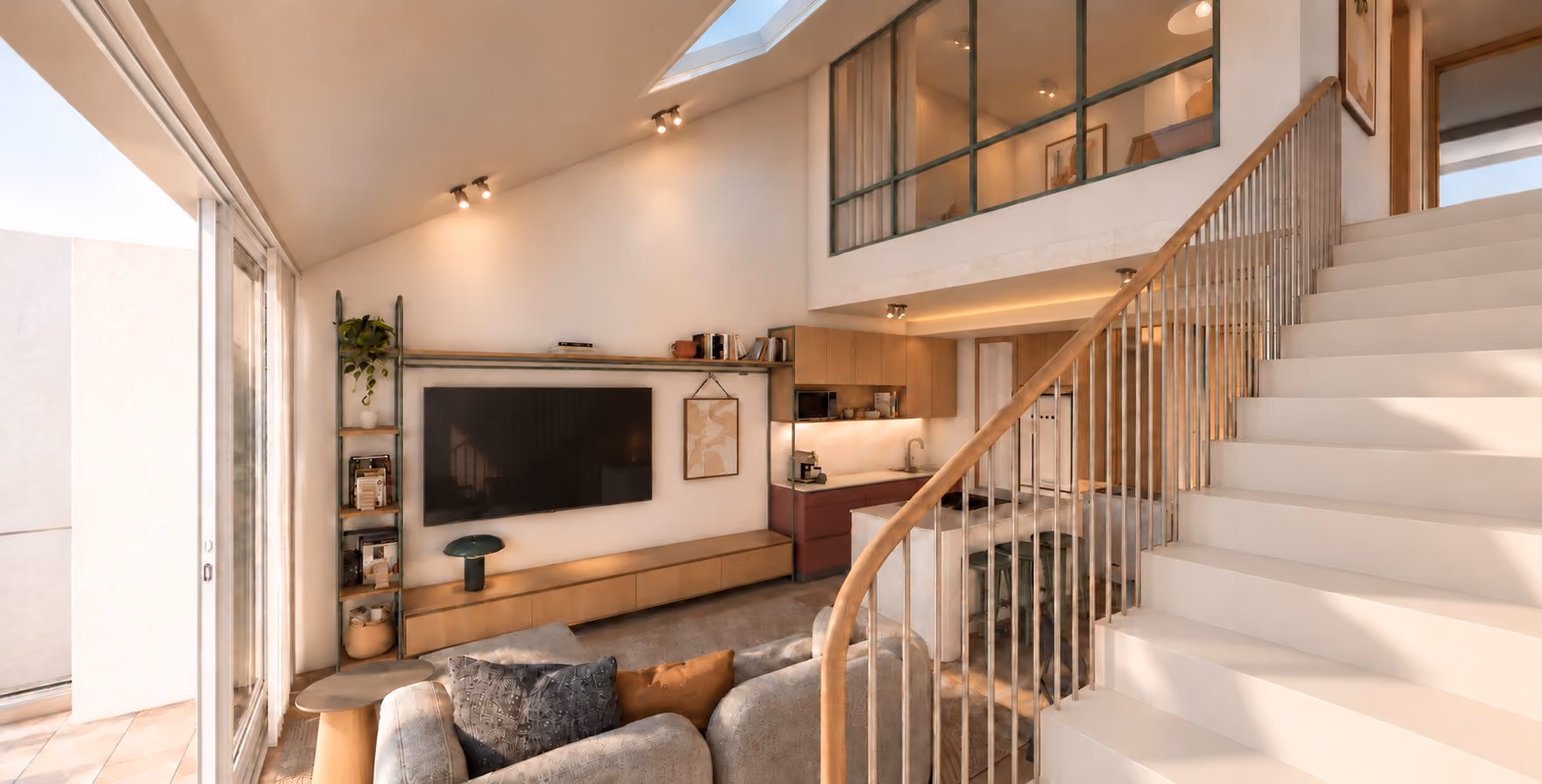 The double-height loft living room with its stair, skylight and glazed screen