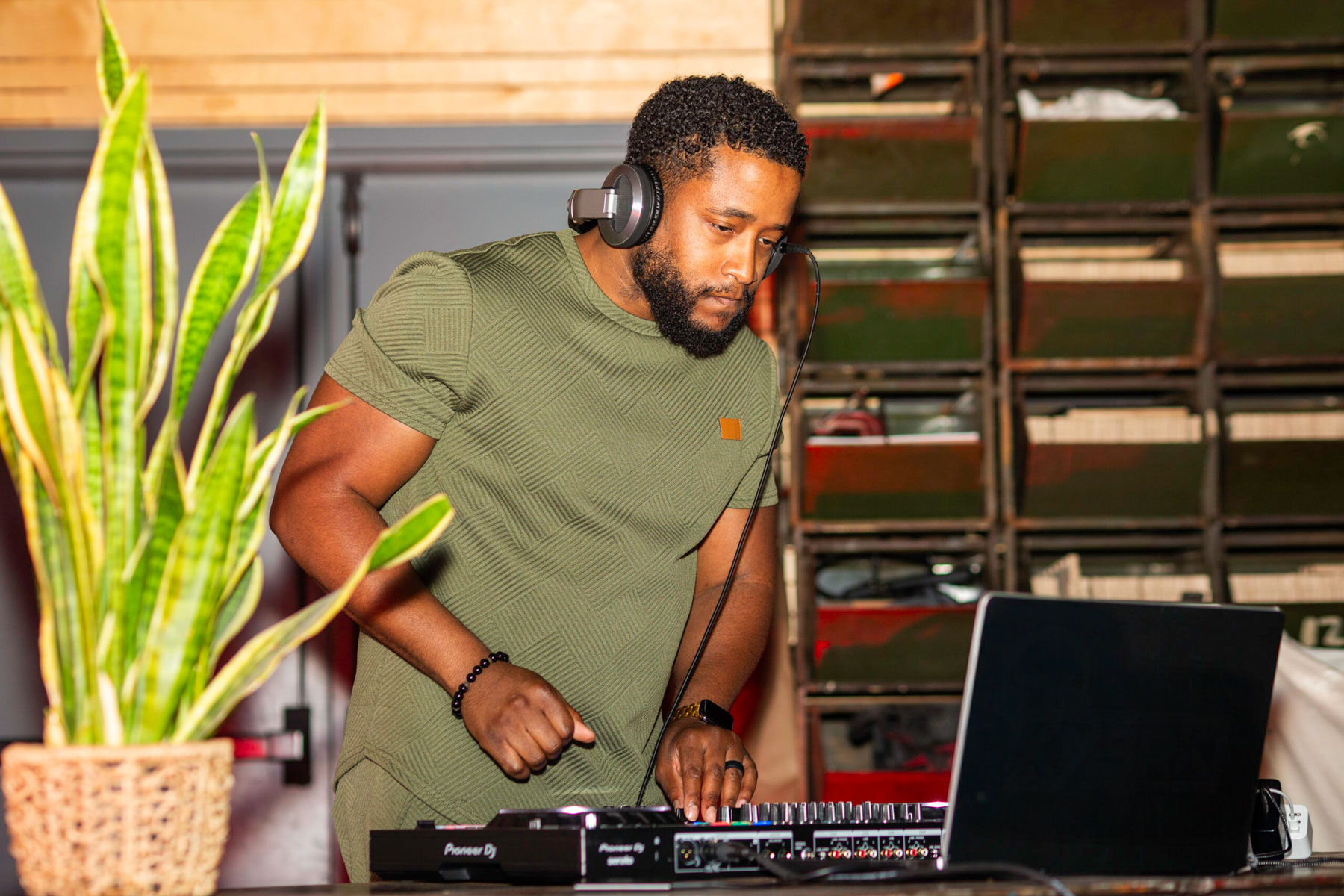 Chicago DJ wearing headphones while mixing music at an intimate indoor event