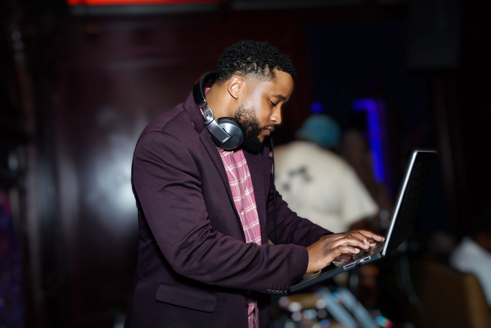 Chicago DJ wearing headphones while cueing music on a laptop during a live event