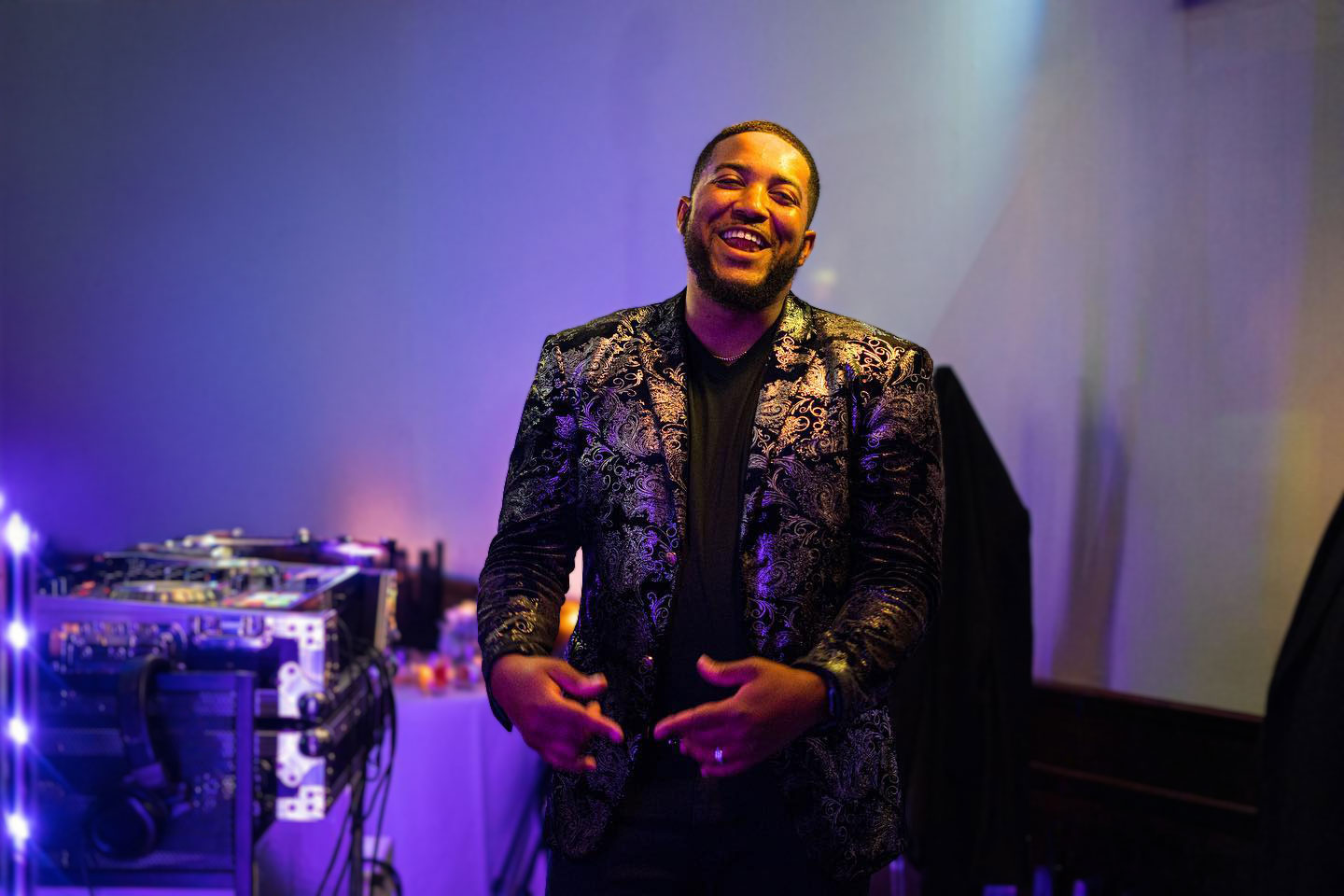 Chicago wedding DJ smiling while performing at the DJ booth during an upscale private event