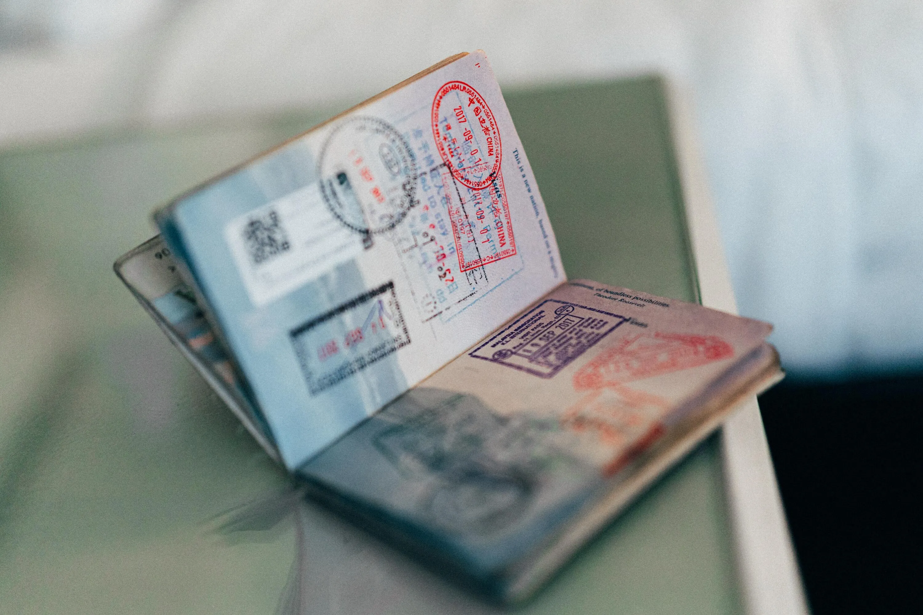 an open passport on the table with lots of stamps