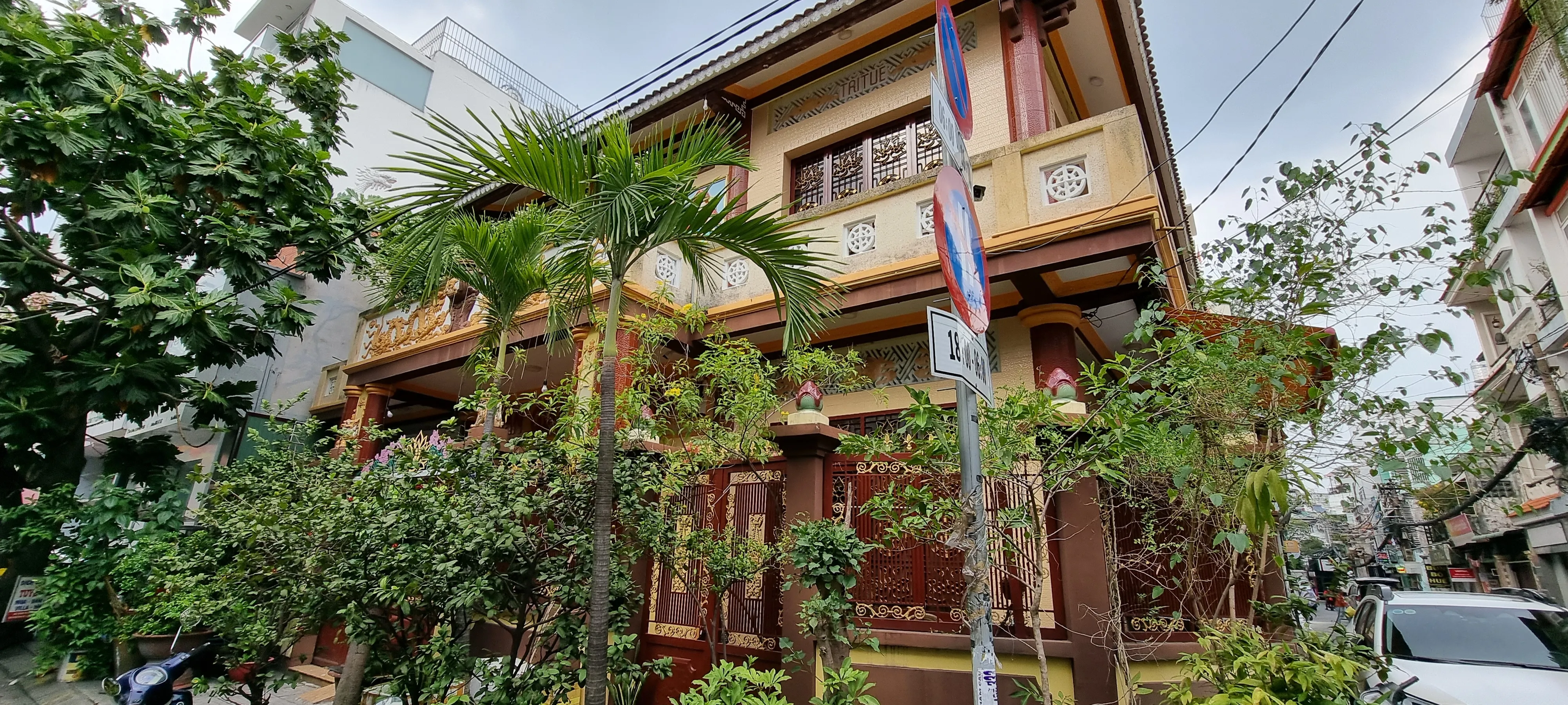 a traditional looking building in ho chi minh city with lots of greenery around it and fences surrounding the beautiful decor
