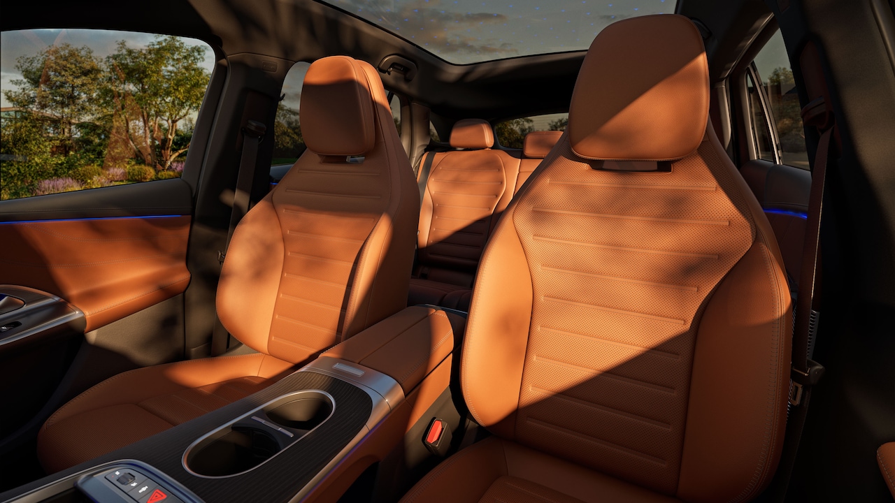 Side view of the interior through the open driver/passenger door, showing the sports seats with various extras.
