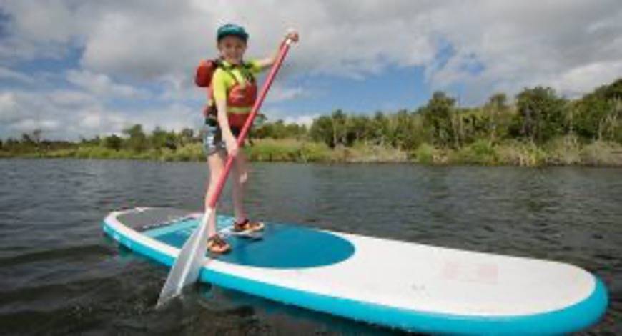 young girl paddle boarding at Rotorua Paddle Tours