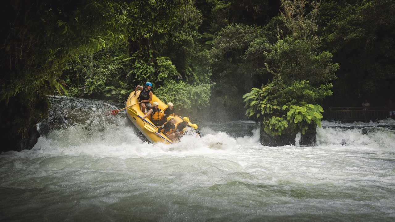 a raft going over the powerhouse rapid on the kaituna river in rotorua