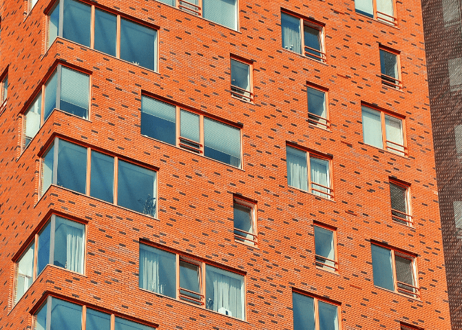 The side of a red brick apartment block.
