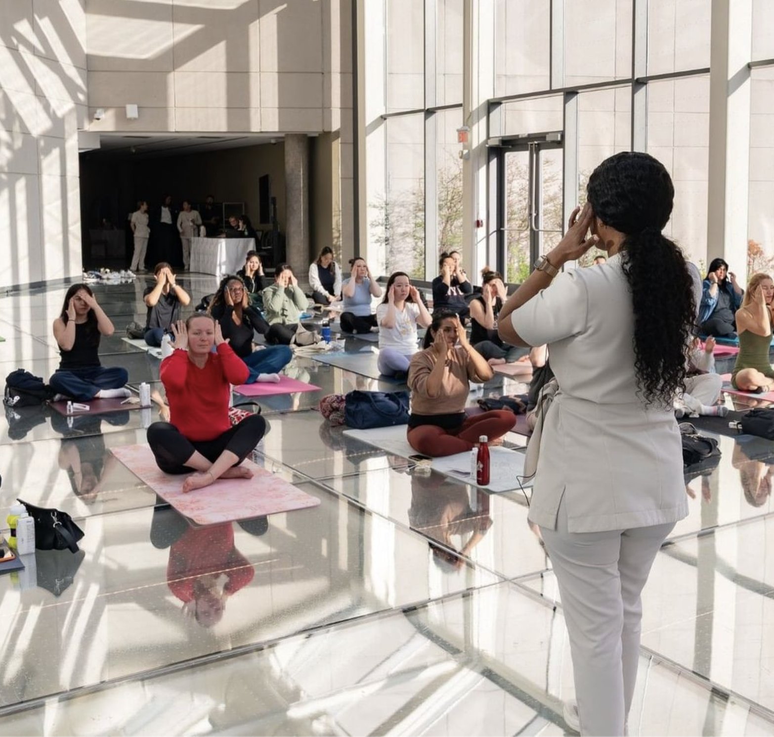 Wellness instructor leading a group class on yoga mats