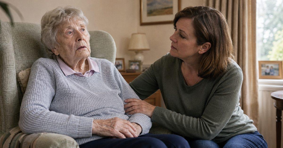 An adult daughter looking concerned as she sits beside her elderly mother, who appears confused and distant, in a comfortable home living room.
