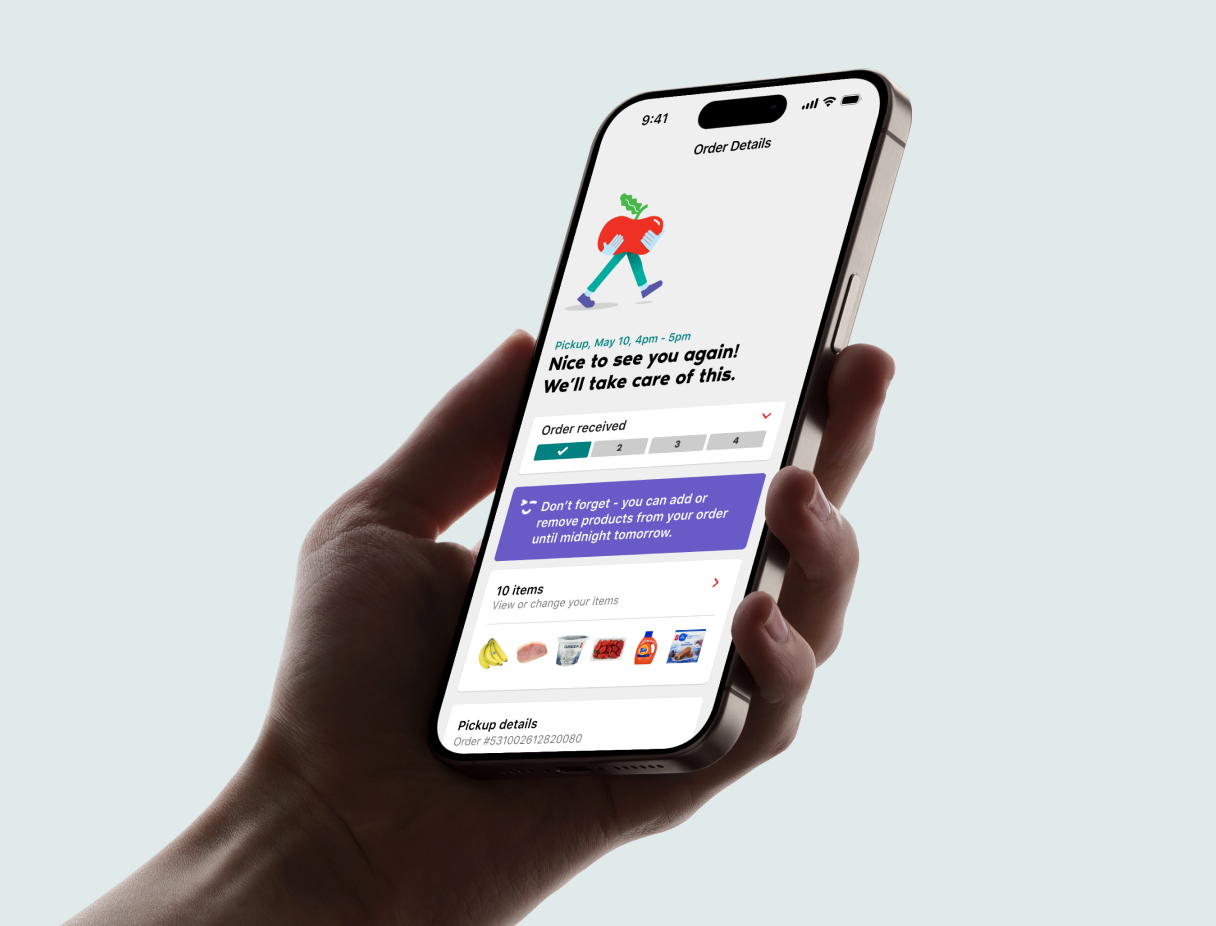 Phone screen showing a pickup store confirmation dialog. A dark grey map of downtown Toronto is in the with two store location pins to the left of the phone screen.