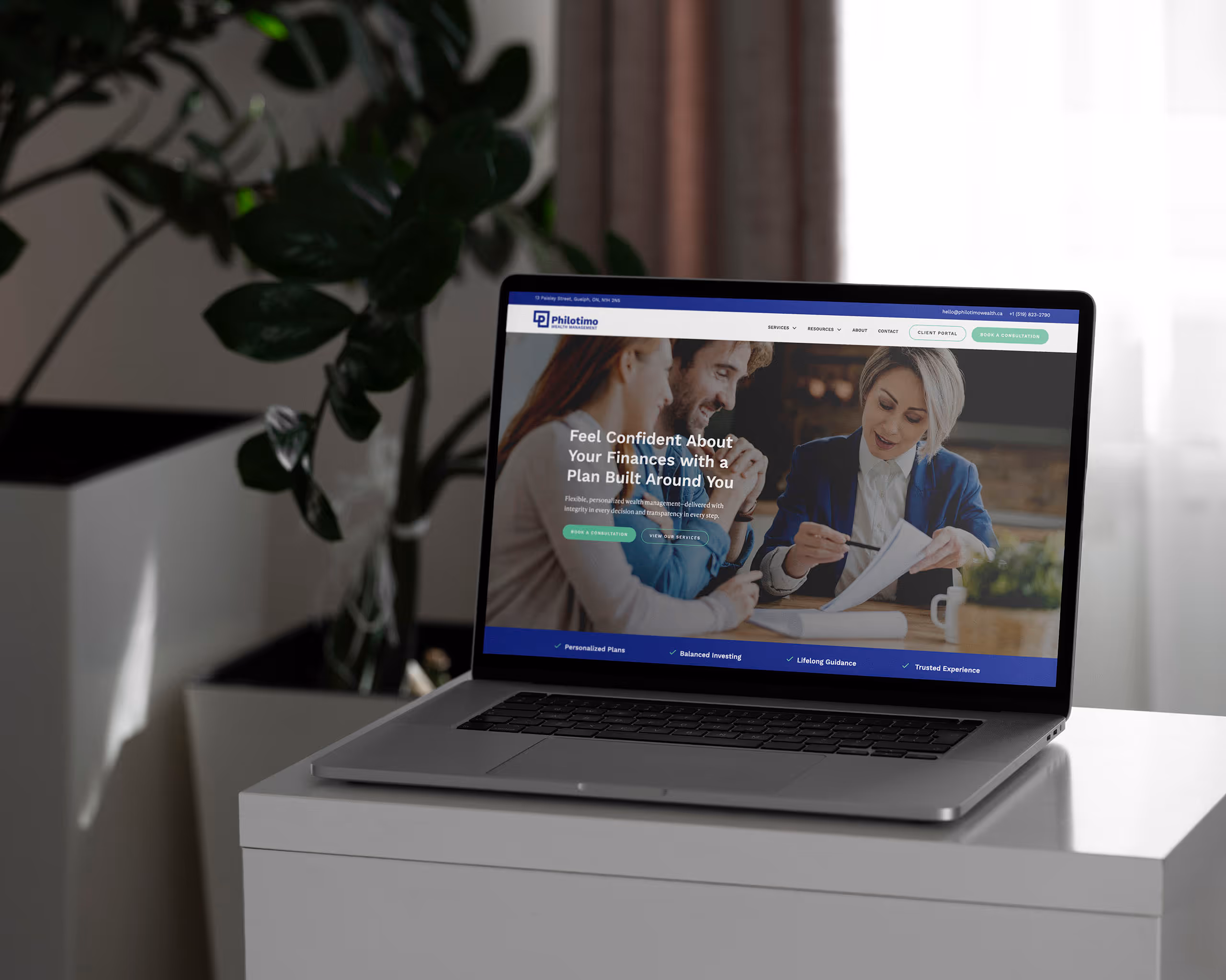 Square sign on the side of a brick building featuring the Philotimo Wealth Management logo symbol.