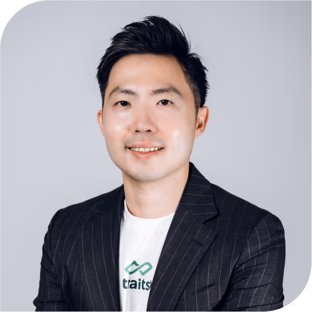Portrait of Anthony Koo, team member at StraitsX, dressed in a black blazer against a neutral background.