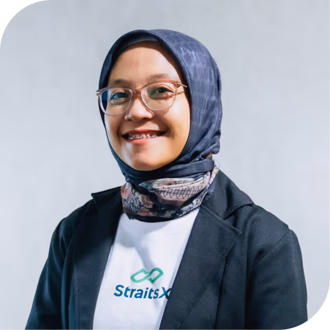 Portrait of Desi Purnamasari, team member at StraitsX, dressed in a navy blazer against a neutral background.