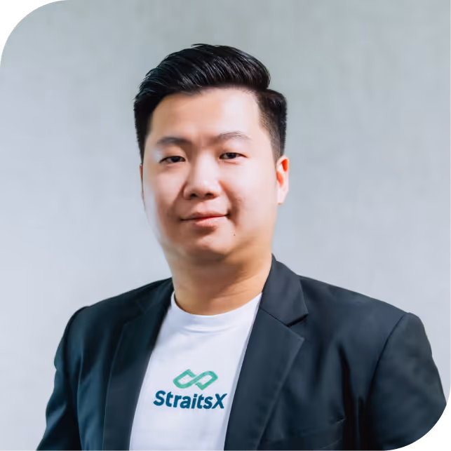 Portrait of Kenny Yan, team member at StraitsX, dressed in a navy blazer against a neutral background.