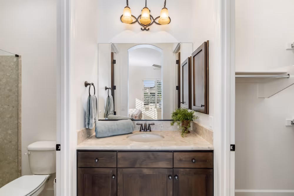Toilet sink with towels and a mirror