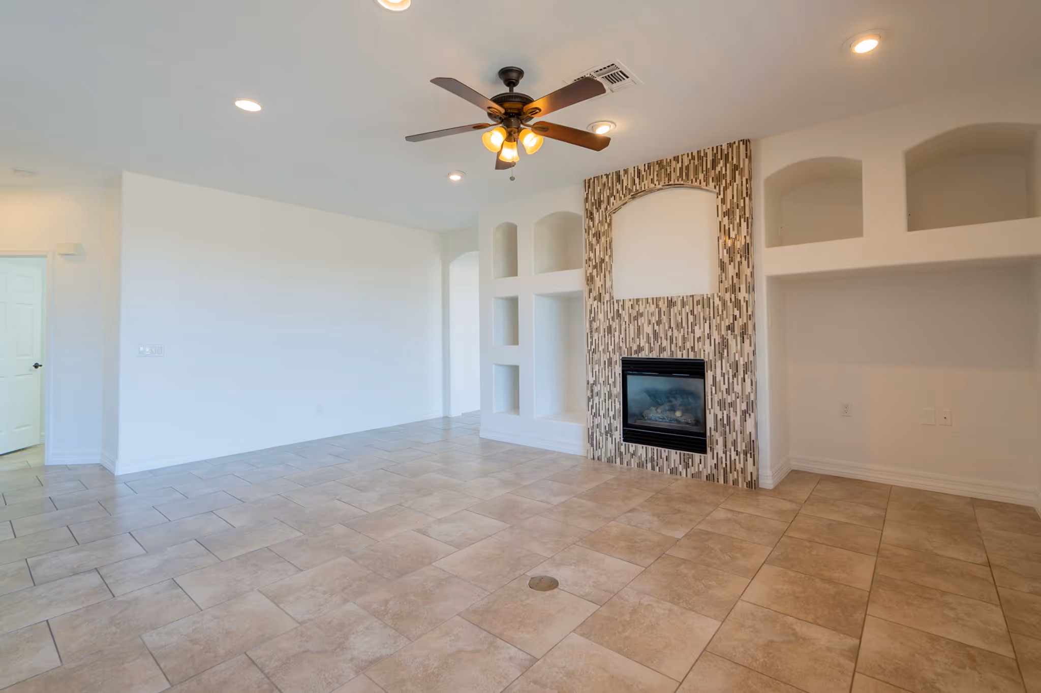 A photo of an empty room with a fireplace