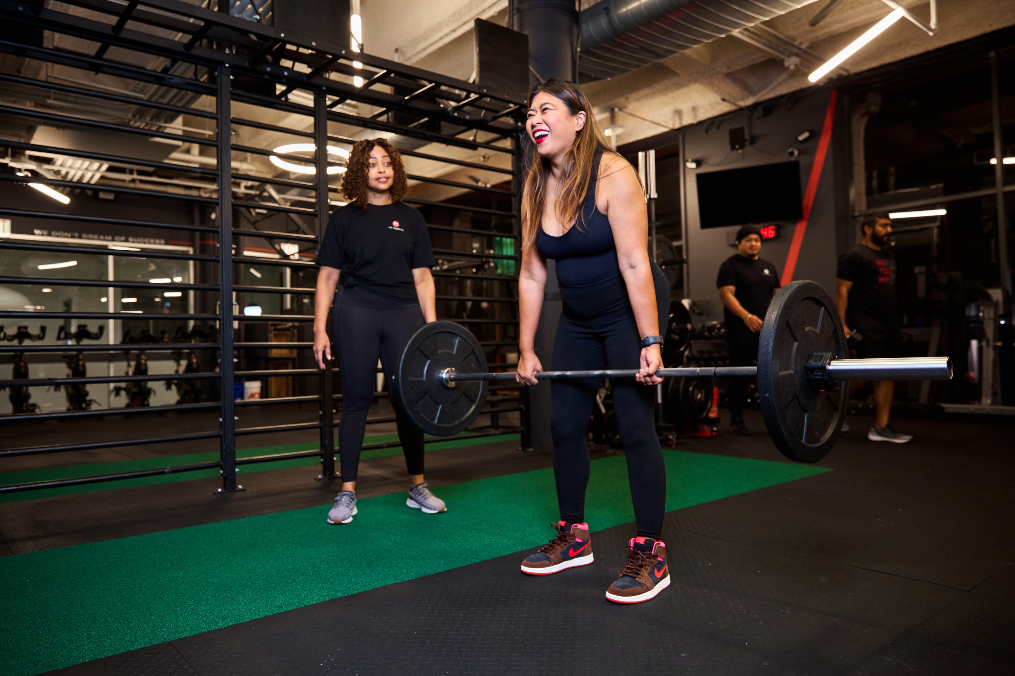 The image depicts a fitness enthusiast performing a squat with proper form, showcasing lean muscle growth and strength training techniques. The background features gym equipment, emphasizing the importance of resistance training and building muscle mass for overall health and fitness.