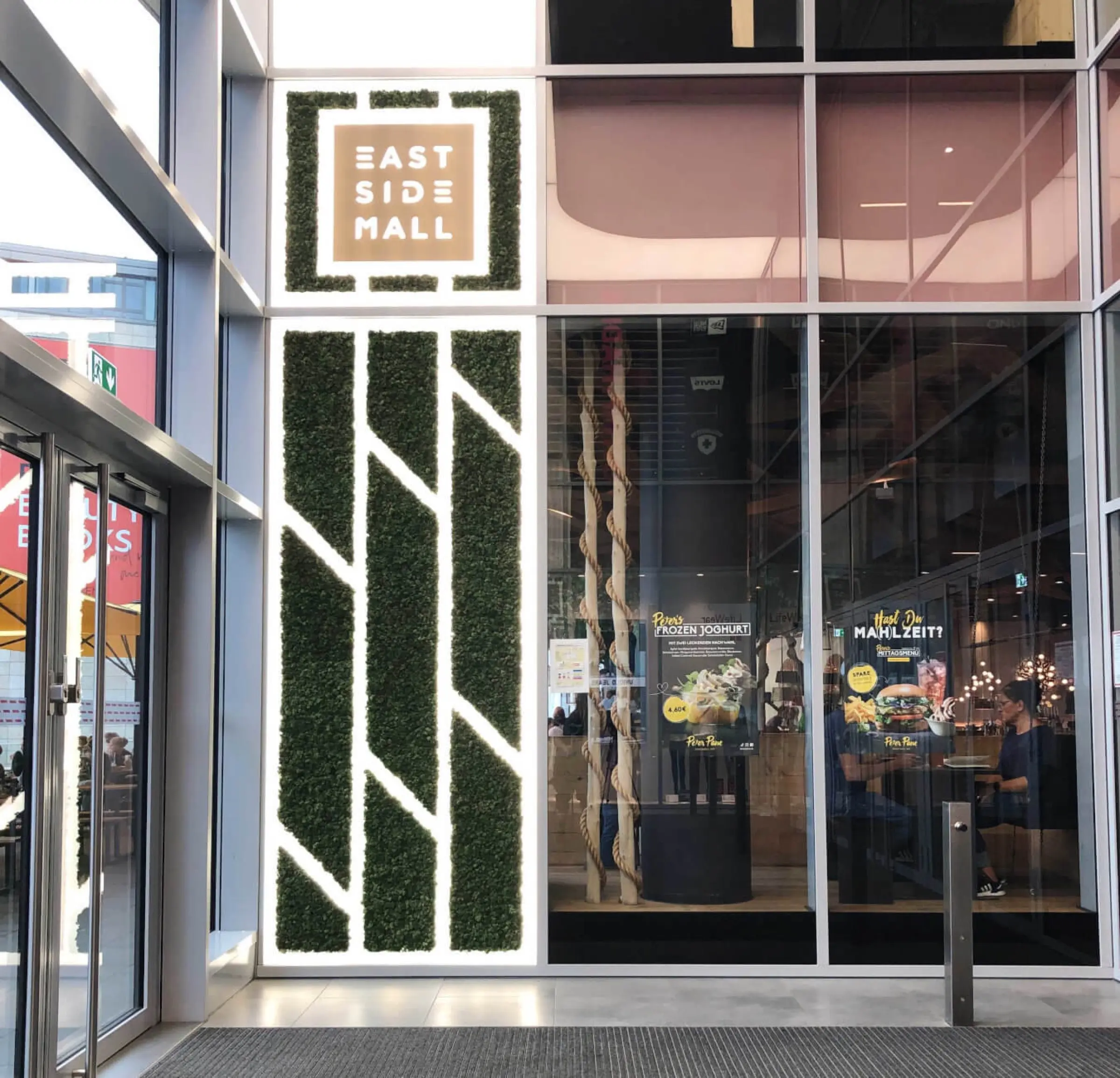 Gestaltung des Eingangsbereichs der East Side Mall mit Rentiermoos im CI-Muster