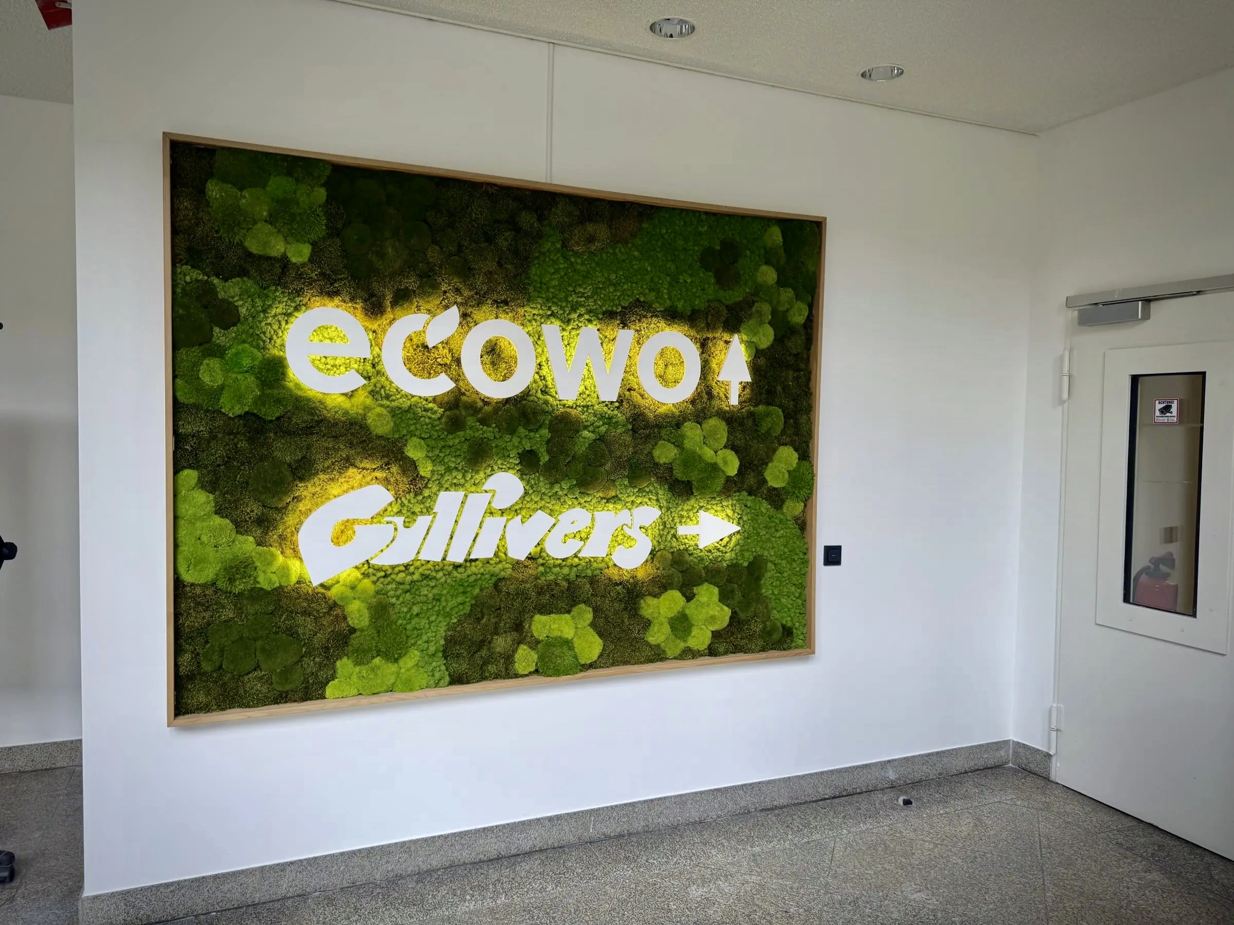 Solid Oak Frame with Backlit Dual Logos and Moss Mix in the Ecowo Lobby