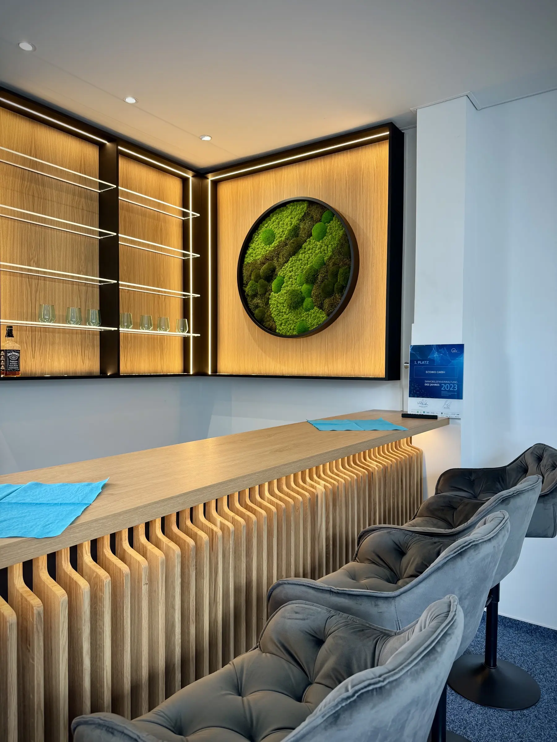 Integrated round moss mix artwork into a backlit cabinet, including complete design, planning, fabrication of cabinets and custom bar.