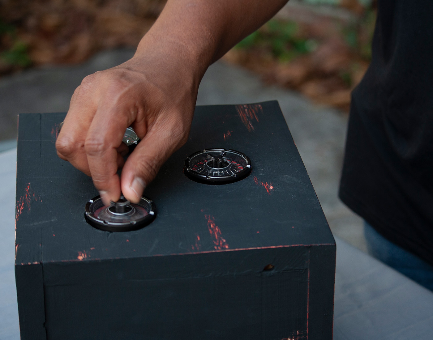 User spings dials on a black wooden box